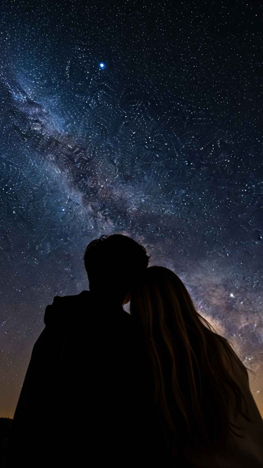 Couple stargazing under a clear night sky, symbolizing eternal love.