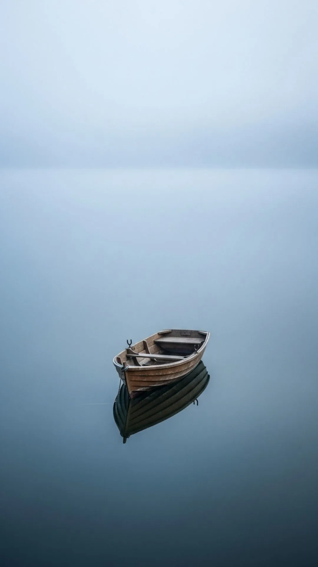 A single boat alone on a calm lake, a peaceful and lonely DP for WhatsApp.
