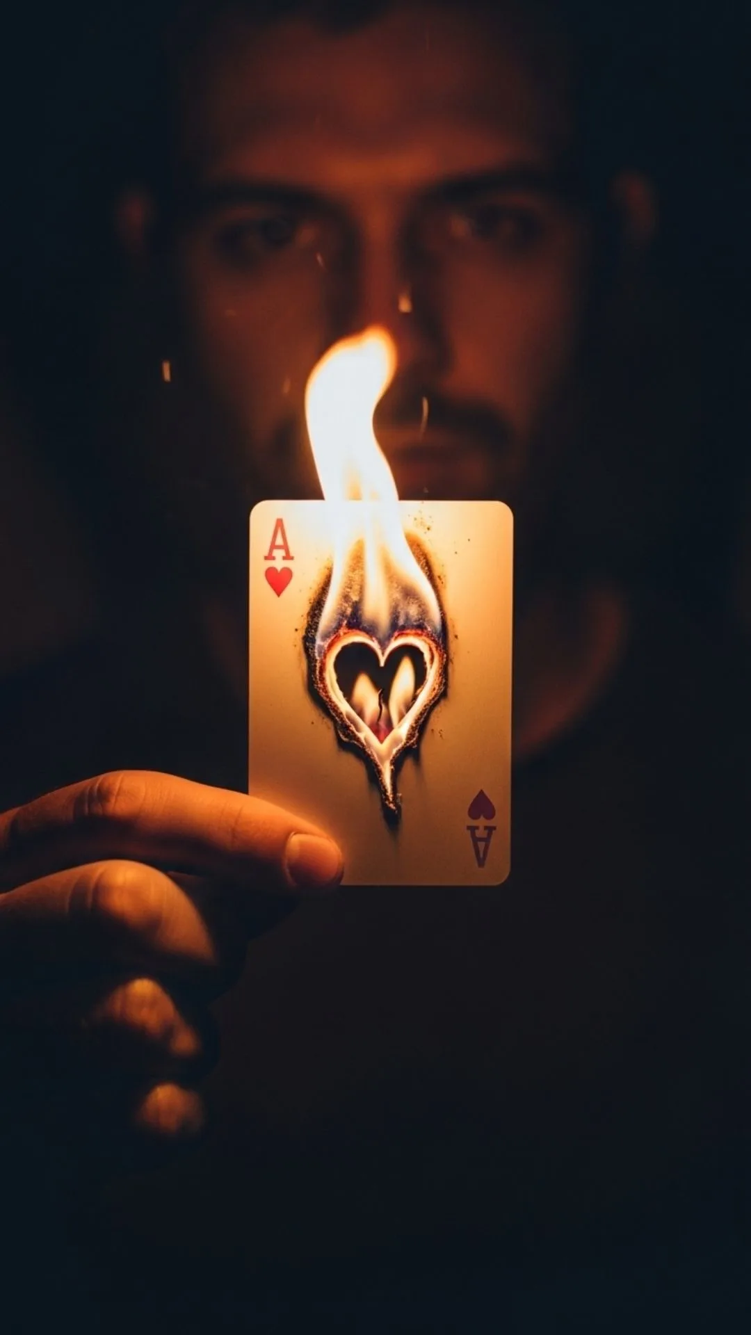 An angry and sad boy DP showing a hand burning the ace of hearts card, a powerful image of pain and ending a love failure