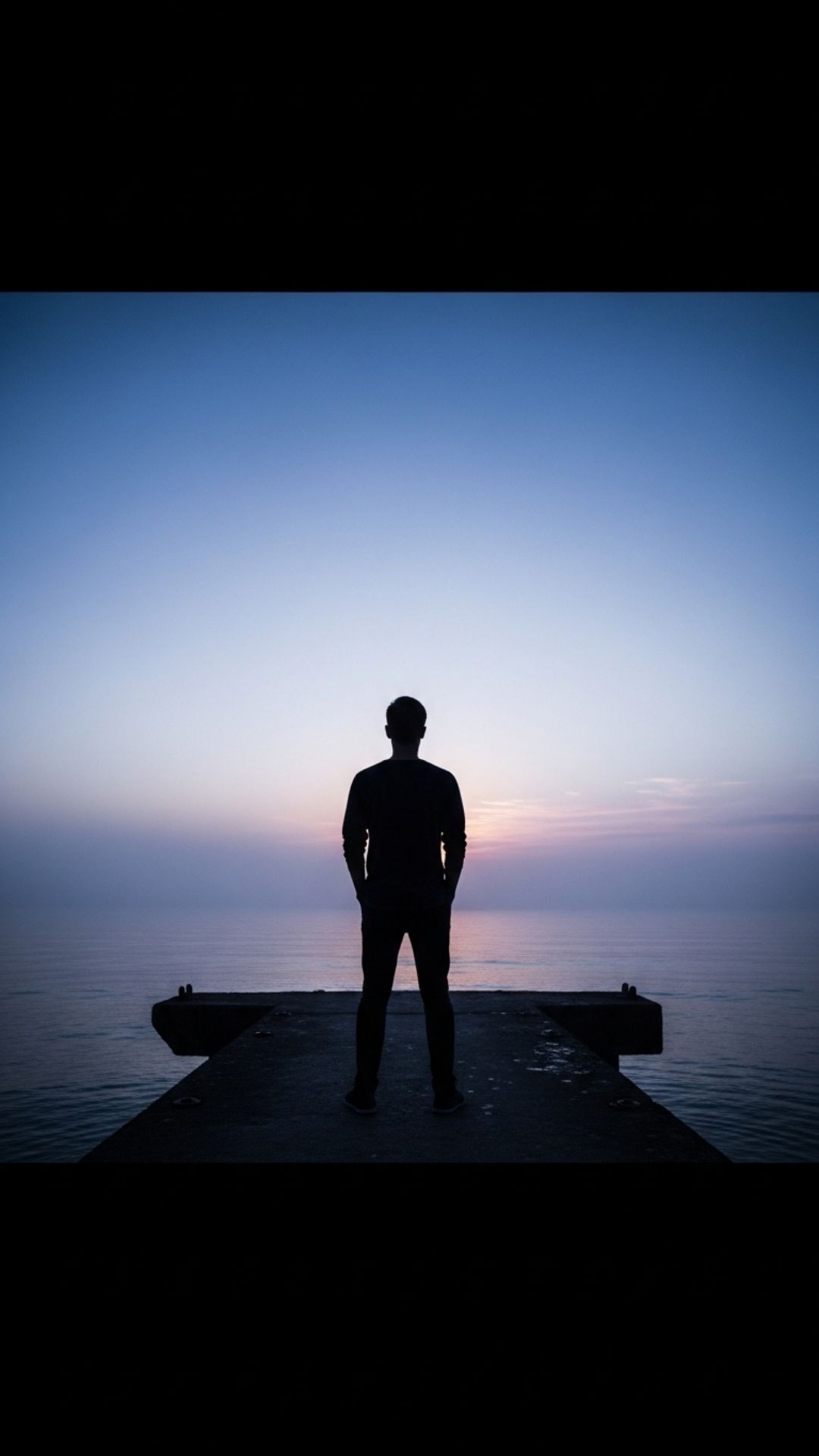 A cinematic silhouette of a man standing on a foggy pier at dawn, representing quiet strength, loneliness, and introspection after heartbreak