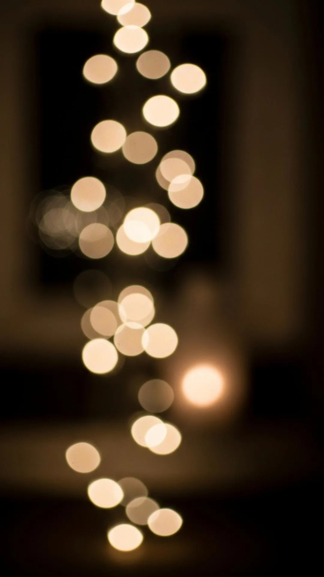 Shimmering candlelight bokeh, representing a warm glow in darkness.
