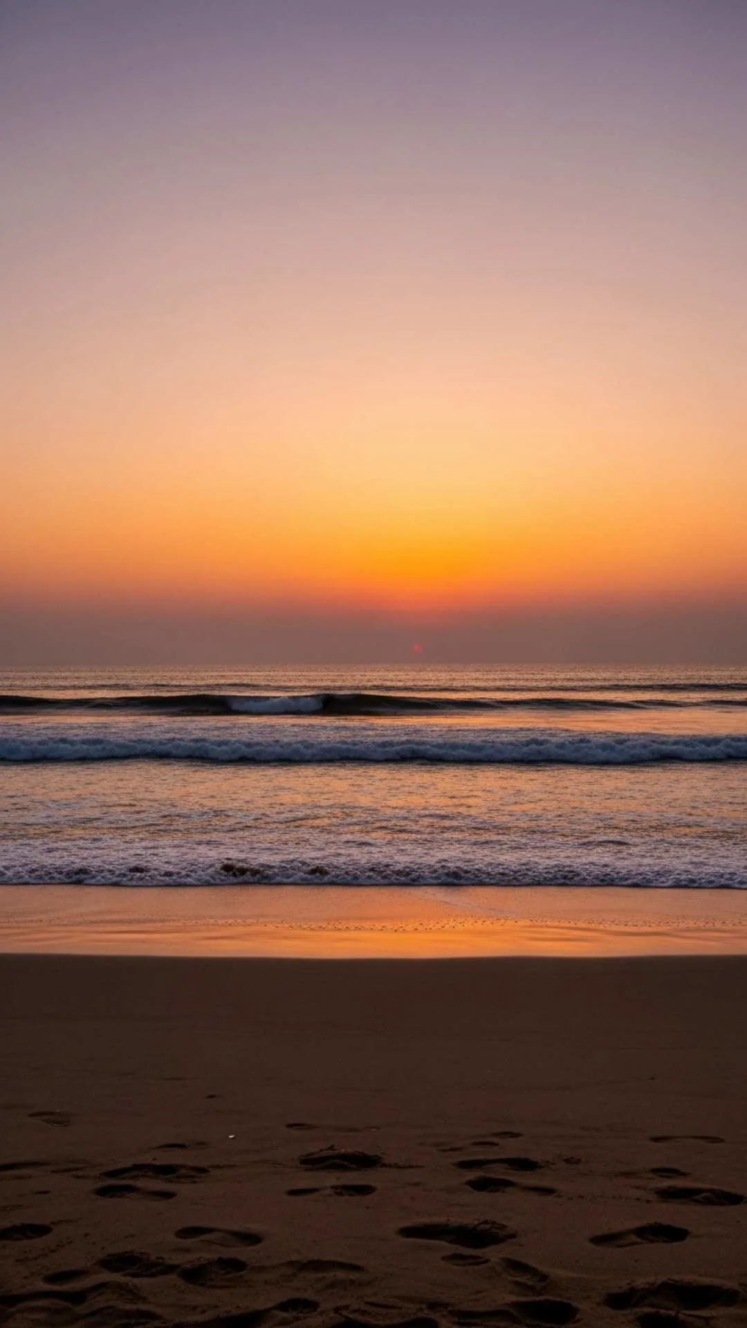 Tranquil Indian beach at dusk with footprints, symbolizing healing