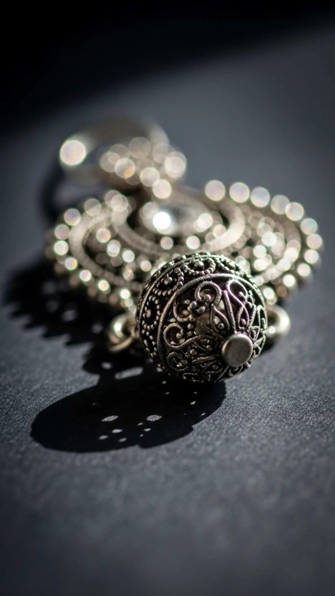 Indian jewelry reflection DP, antique silver earring, intricate light patterns, dark aesthetic background, cultural accessory profile, glittering art.