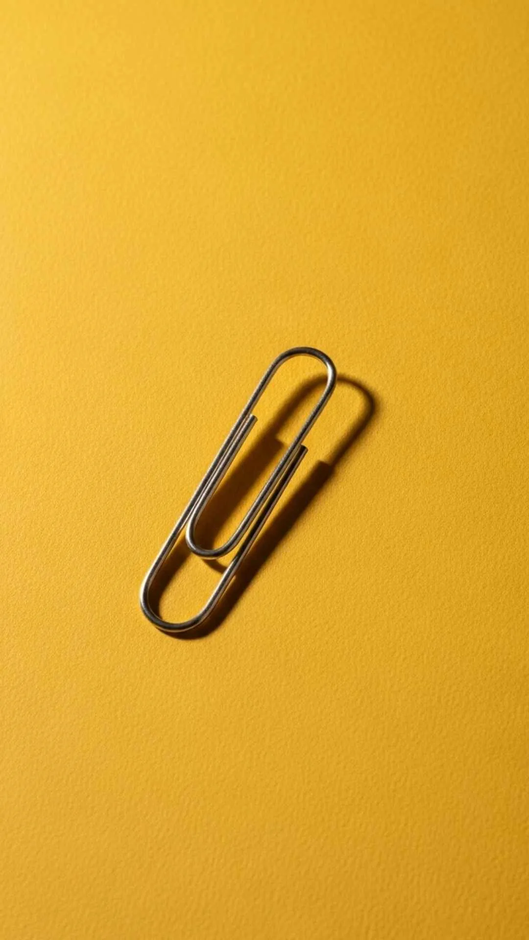 A simple minimalist DP of a single paperclip on a colored background, finding beauty and design in everyday objects. #MinimalistObject #EverydayBeauty #SimpleDP #Design #Paperclip