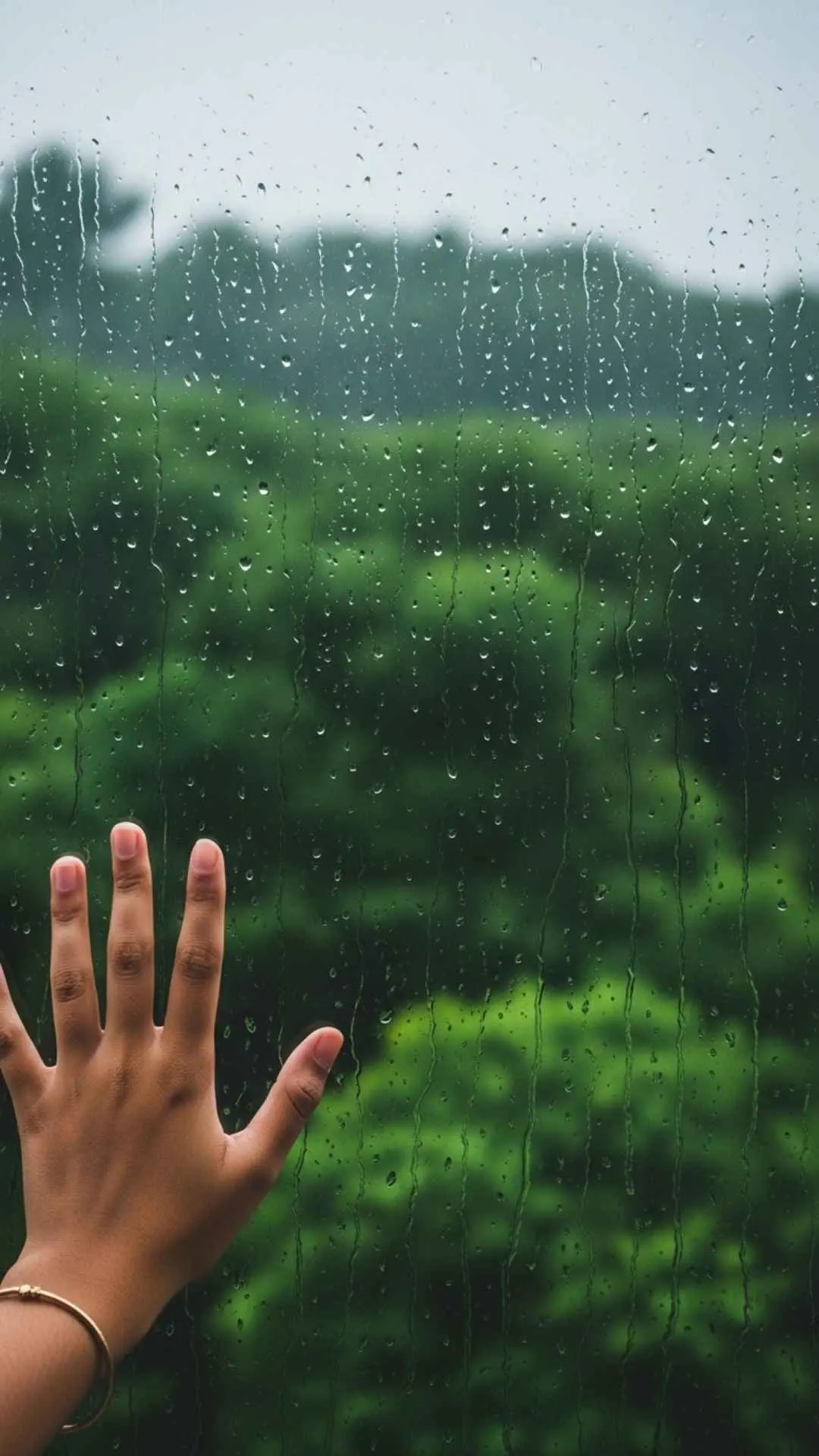 Monsoon rain aesthetic DP, raindrops on glass, blurry green foliage background, reflective mood, Indian weather vibe, sad rainy profile.
