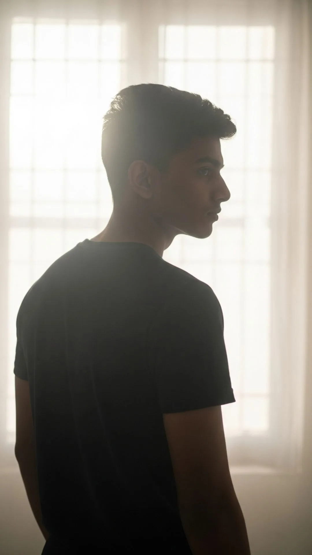 Mysterious silhouette of a young man, back-lit, conveying a cool and enigmatic Instagram DP for boys.