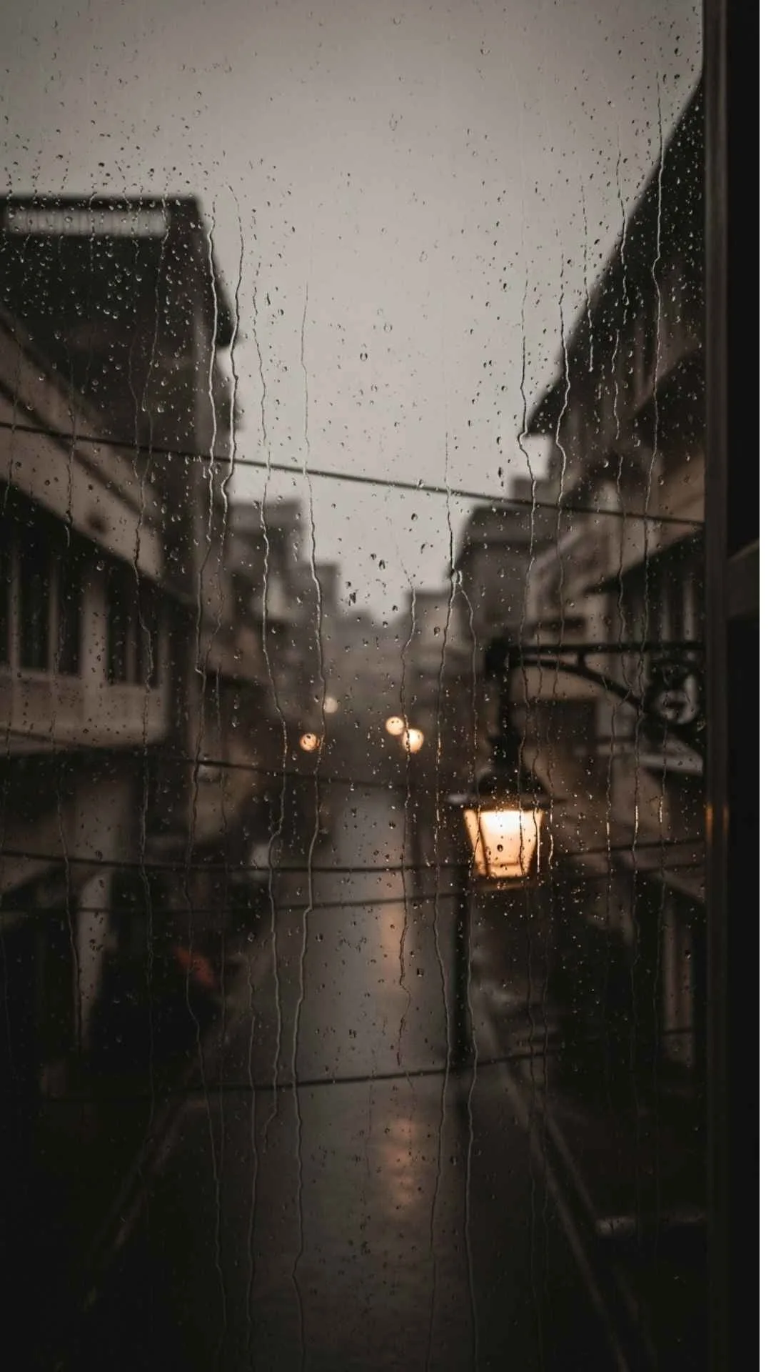 Sad city street DP, monochrome rainy cityscape, blurry urban view, lonely Indian street, melancholic mood profile picture.