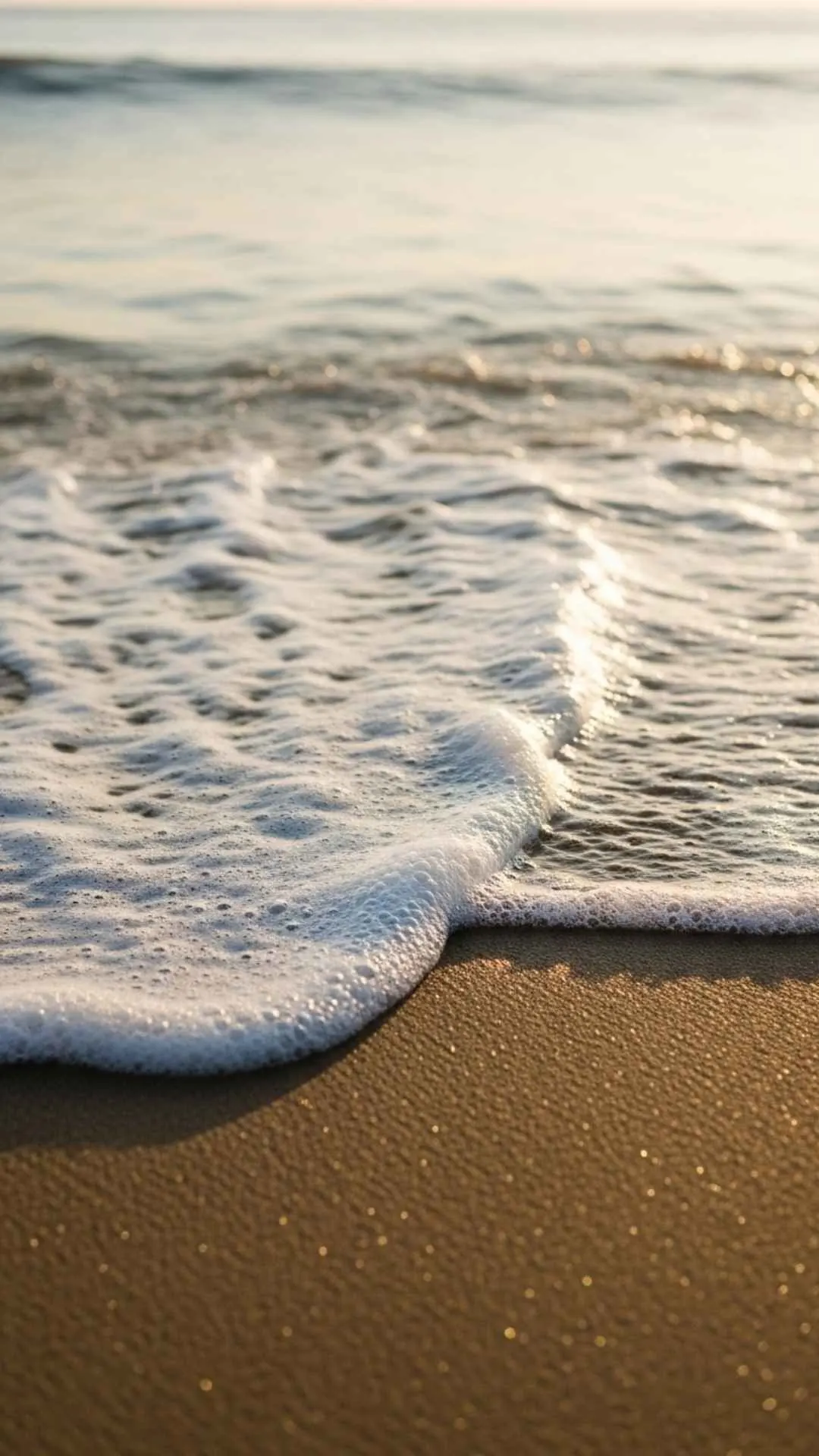Gentle seafoam from a wave washes over the sand. A healing and meditative nature DP for finding calm and reducing stress.