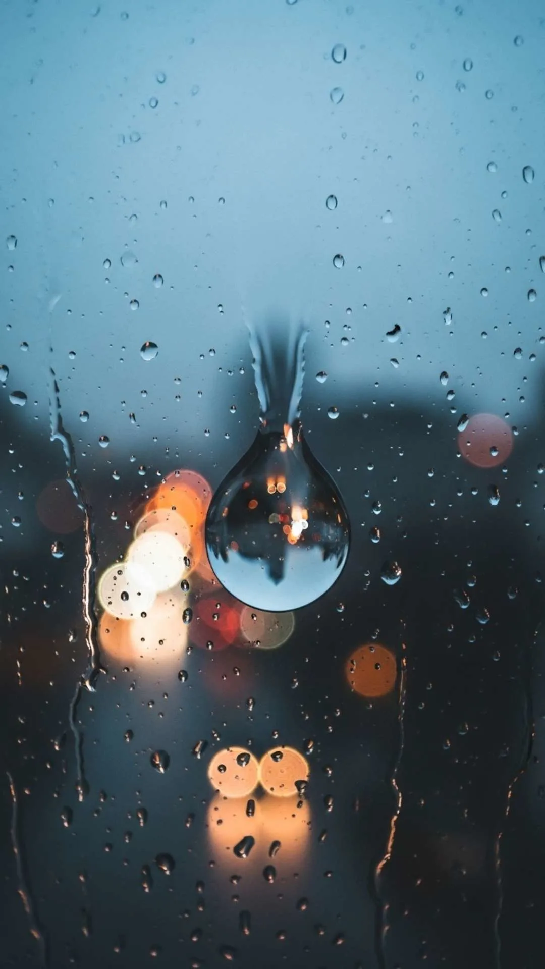 Poignant unique sad DP of a single raindrop on a window, with blurred city background, conveying quiet reflection for WhatsApp.
